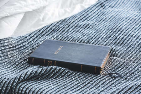 Holy Bible on bed in room