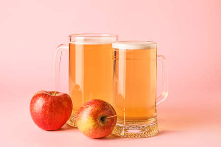 Mugs of apple cider on color backgroundの写真素材