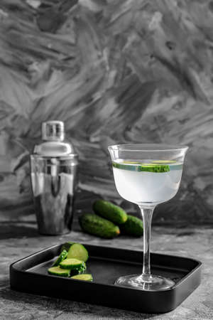 Glass of tasty cucumber martini and shaker on tableの写真素材