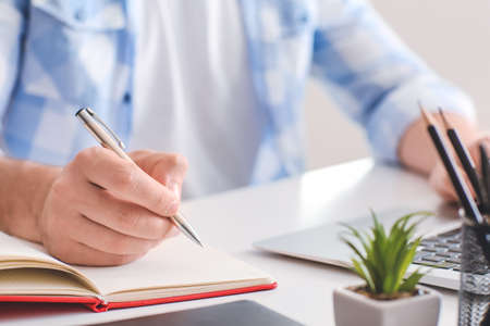 Man with laptop working at home, closeup