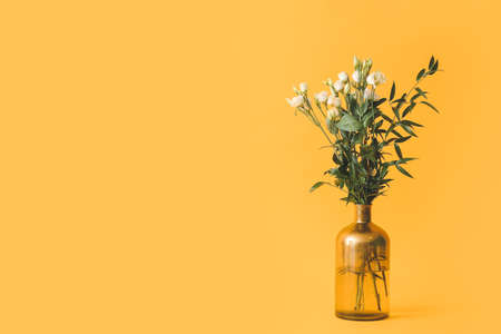 Vase with bouquet of flowers on color backgroundの写真素材