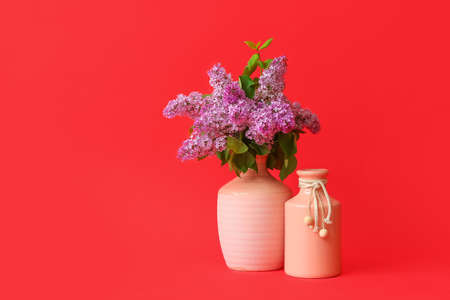 Different vases with bouquet of flowers on color backgroundの写真素材