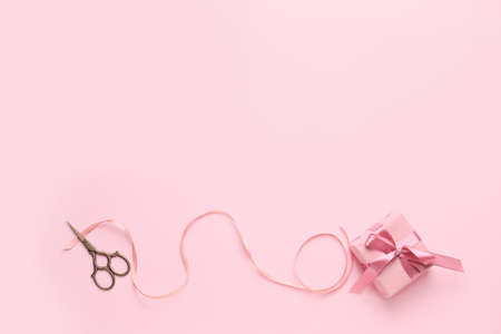 Gift box with scissors on color backgroundの写真素材