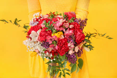 Young woman with beautiful bouquet on color background, closeupの写真素材
