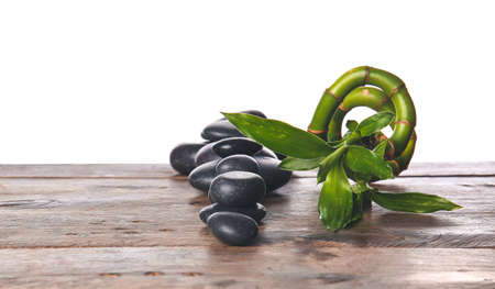 Zen stones and bamboo on table against white backgroundの写真素材