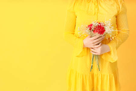 Young woman with beautiful bouquet on color backgroundの写真素材