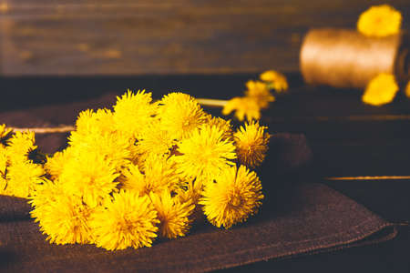 Beautiful dandelions on dark tableの写真素材