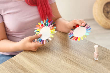 Female client choosing color of nail polish in beauty salonの写真素材