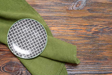 Clean plate with napkin on wooden backgroundの写真素材