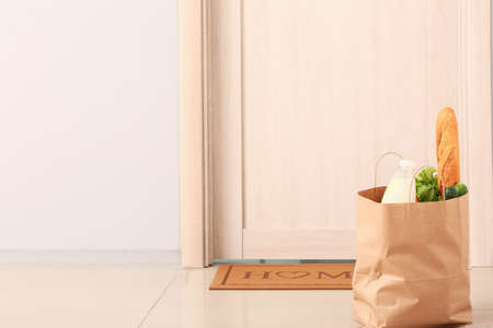 Products left by courier of food delivery service near door. Concept of epidemicの写真素材