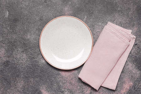 Clean plate with napkin on dark backgroundの写真素材