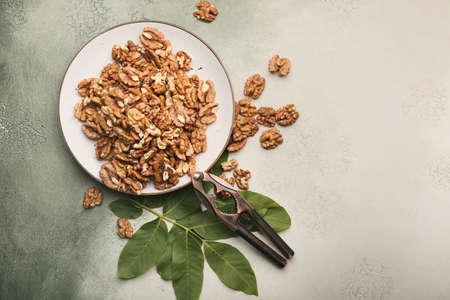 Plate with tasty walnuts on color backgroundの写真素材