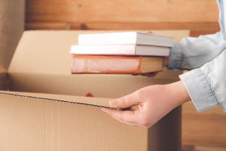 Woman packing moving box at home
