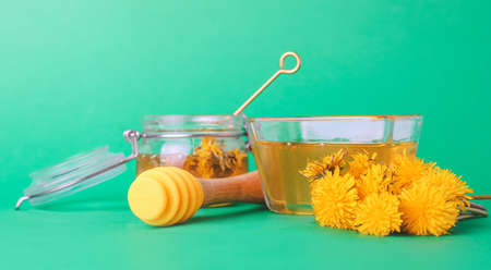 Glassware of sweet dandelion honey on color backgroundの写真素材