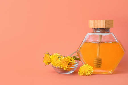 Jar of sweet dandelion honey on color backgroundの写真素材