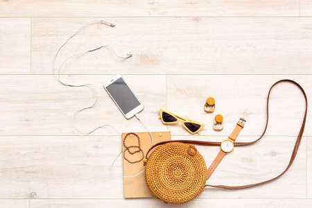 Female accessories with mobile phone on white wooden backgroundの写真素材