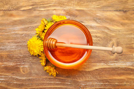 Jar of sweet dandelion honey on wooden backgroundの写真素材