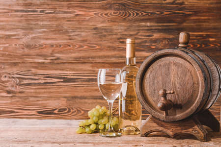 Wooden barrel, bottle and glass of wine on wooden backgroundの写真素材