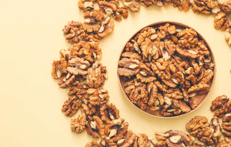 Plate with tasty walnuts on color backgroundの写真素材