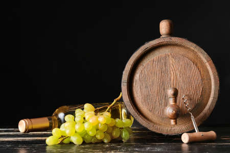 Wooden barrel and bottle of wine on dark backgroundの写真素材