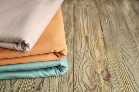 Stack of clean bed sheets on table, closeup