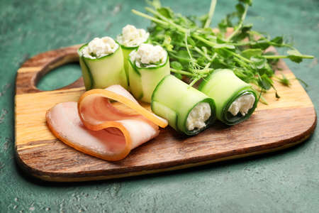 Board with tasty cucumber rolls on tableの写真素材