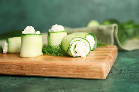 Board with tasty cucumber rolls on tableの写真素材