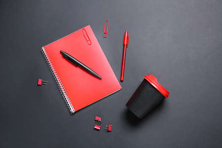 Takeaway cup for drink and stationery on dark backgroundの写真素材