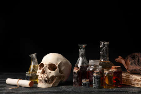 Potions, human skull and old book on alchemist's tableの写真素材