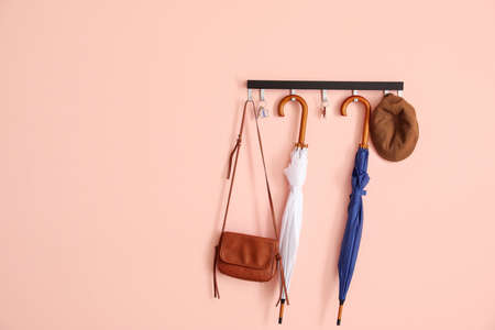 Stylish umbrellas hanging on color wall in hallの写真素材