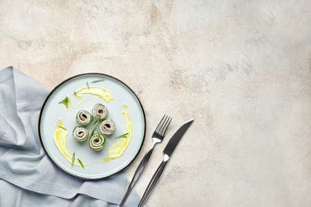 Plate with tasty cucumber rolls on light backgroundの写真素材