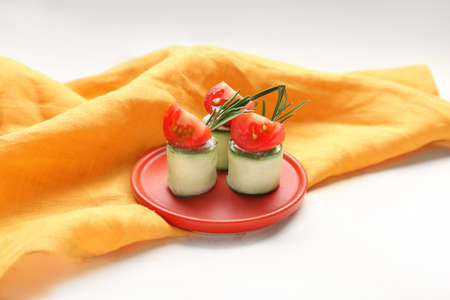Plate with tasty cucumber rolls on white backgroundの写真素材
