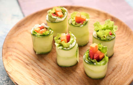 Plate with tasty cucumber rolls on tableの写真素材