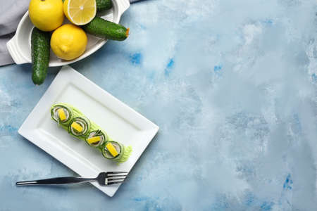 Plate with tasty cucumber rolls on color backgroundの写真素材