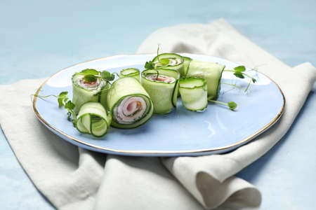 Plate with tasty cucumber rolls on color backgroundの写真素材