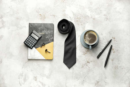 Cup of coffee with male accessories and stationery on light backgroundの写真素材