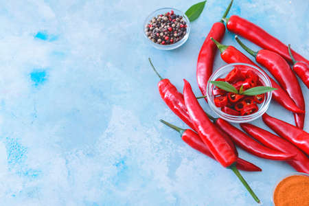 Hot chili pepper with spices on color background