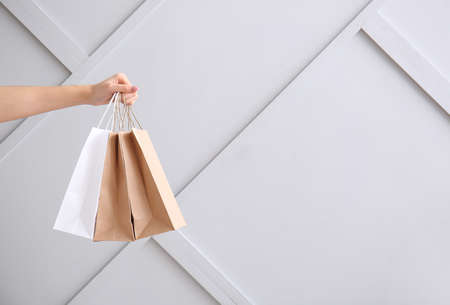 Hand with paper bags on light backgroundの写真素材