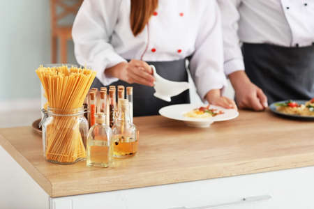 Male and female chefs cooking in kitchenの写真素材