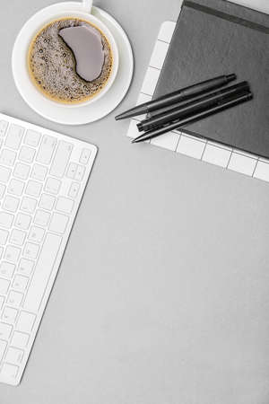 Cup of coffee, stationery and PC keyboard on gray backgroundの写真素材