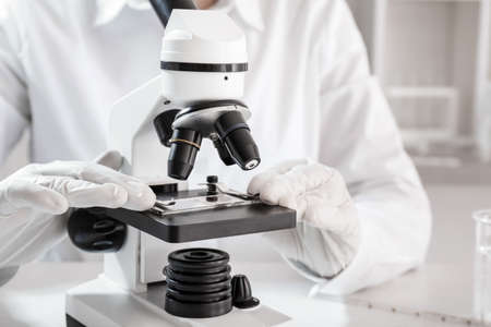 Scientist using microscope in laboratoryの写真素材