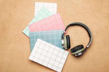 Notebooks and headphones on color backgroundの写真素材