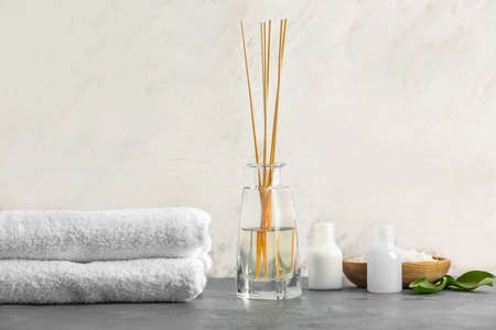 Reed diffuser, towels and cosmetics on tableの写真素材