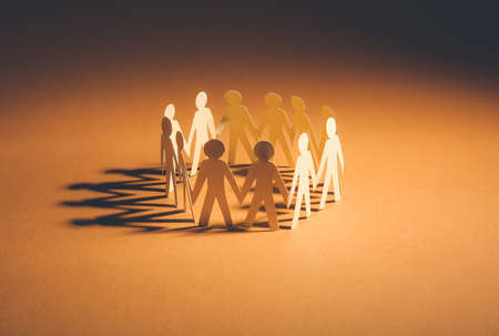 Circle made of paper human figures on table. Unity conceptの写真素材