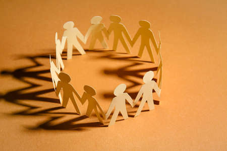 Circle made of paper human figures on table. Unity conceptの写真素材