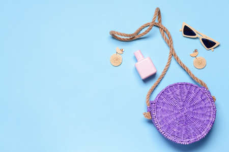 Wicker bag with female accessories on color backgroundの写真素材