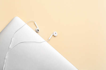Laptop with earphones on color backgroundの写真素材