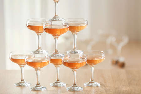 Tower made of glasses with champagne on table indoorsの写真素材