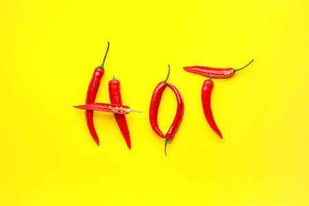 Word HOT made of chili pepper on color background
