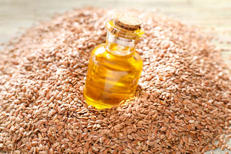 Bottle with flax oil and seeds on tableの写真素材